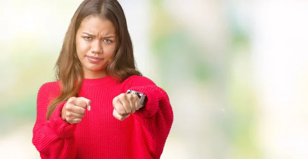 年轻美丽的黑发女人穿着红色的冬季毛衣在孤立的背景拳打脚踢战斗 侵略性和愤怒的攻击 威胁和暴力 — 图库照片