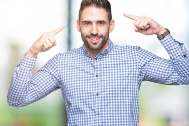 Yakışıklı delikanlı izole arka plan üzerinde her ikisi ile baş gösteren gülen eller parmak, harika bir fikir ya da düşünce, iyi hafıza