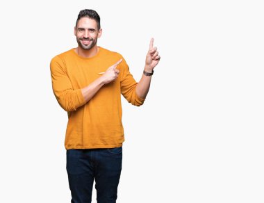 Yakışıklı delikanlı gülümseyen ve iki elleri ve parmakları ile tarafına işaret kamera bakarak izole arka plan üzerinde.