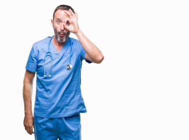 Sürpriz yüz, göz parmaklarının arasından seyir ile ok jest yapıyor izole arka plan üzerinde tıbbi üniforma giyen orta yaş ağarmış kıdemli Doktor adam şok. İmansız ifade.