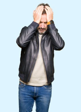 Orta Çağ yakışıklı adam siyah deri ceket giymiş baş ağrısı çaresiz muzdarip ve stres çünkü ağrı ve migren. Eller baş.