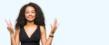 Kendinden emin ve mutlu gülümseyerek süre yedi numara ile gösterilen ve parmakları ile işaret kıvırcık saçlı giyen moda etek genç güzel kız.