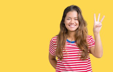 Genç güzel esmer kadın giyiyor çizgili t-shirt gösterilen ve parmakları ile işaret izole arka plan üzerine üçüncü gülümseyen ise kendinden emin ve mutlu.