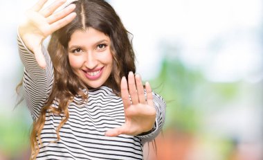 Çerçeve kullanarak yapıyor gülen eller avuç içi ve parmaklar, kamera perspektif kazak giyen genç güzel kadın çizgili