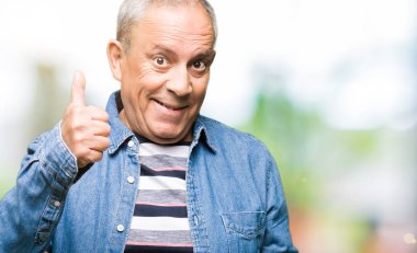 Hareketi el ile mutlu yaşasın yapıyor kot ceket giymiş yakışıklı komuta sizde. Kameraya bakarak başarı gösteren ile ifade onaylama.