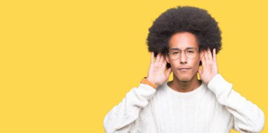 Genç African Amerikan adam ile afro saç gözlük giyiyor iki elini de kulak jestinde duymaya çalışıyorum, dedikoduyu merak ediyor. İşitme sorunu, sağır