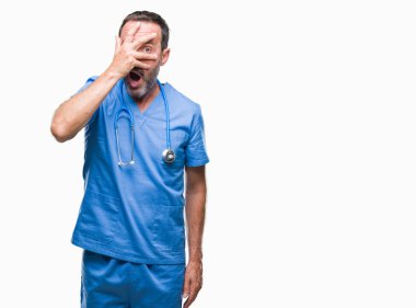Yüz ve gözler el ile kapsayan şok izole arka plan bakmak üzerinde tıbbi üniforması orta yaş ağarmış kıdemli Doktor adam utanç ifadesi ile parmaklarımın arasından bakan.