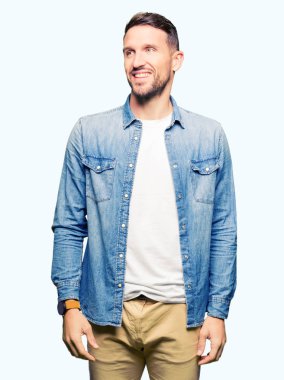 Denim ceket uzak tarafına gülümseme ile yüzünde, doğal ifade arıyorum giyen sakal ve mavi gözlü yakışıklı adam. Kendine güvenen gülüyor.