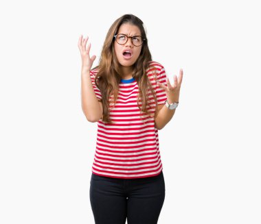 Gözlük ve çizgili giyen genç güzel esmer kadın t-shirt izole arka plan çılgın ve kızgın bağırarak ve agresif ifade ve silah ile bağırmaya üzerine kaldırdı. Hayal kırıklığı kavramı.