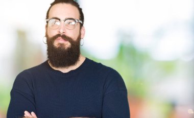 Uzun saç ve sakal görünümlü yan ve dik dik bakma uzağa düşünce gülümseyen gözlüklü genç hipster adamla.