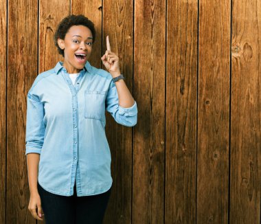 Genç güzel Afrikalı-Amerikalı kadın başarılı fikirle parmağı yukarıyı izole arka plan yüzünden. Çıktıktan ve mutlu. Bir numara.