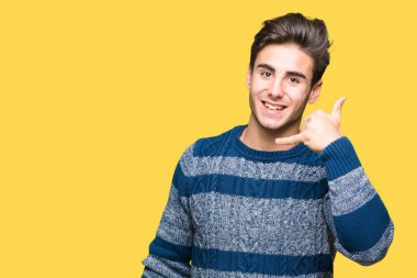 Yakışıklı delikanlı yapıyor gülümseyen izole arka plan üzerinde telefon hareketi ile el ve parmak telefonda konuşuyor gibi. Kavramları iletişim.