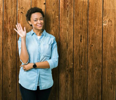 İzole arka plan Waiving Merhaba mutlu genç güzel Afrikalı-Amerikalı kadın ve gülümseyen, dostça karşılama jest