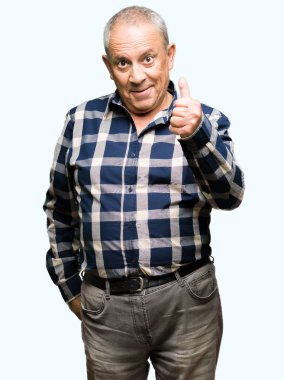 Rahat gömlek giyen yakışıklı kıdemli adam el ile jest kadar mutlu başparmak yapıyor. Başarı göstererek kameraya bakarak ifadeyi onaylama.