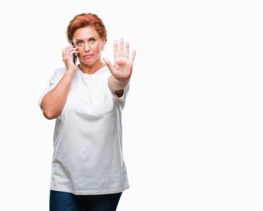 Atrractive üst düzey beyaz Kızıl saçlı kadın Smartphone'da açık eliyle dur işareti ile ciddi ve kendine güvenen ifade, savunma jest yapıyor izole arka plan üzerinde söz
