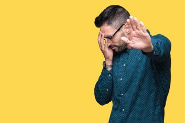Üzerinde gözlük takan genç yakışıklı iş adamı izole elleriyle gözlerini kapsayan arka plan ve stop jest ile acı ve korku ifadesi. Utandım ve negatif kavramı.