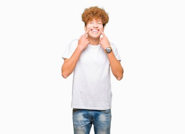 Casual beyaz t-shirt gülen açık ağızlı giyen afro saçlı genç yakışıklı adam, işaret ve neşeli zorla parmak gülümse