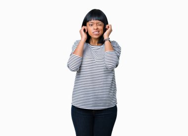 Yüksek sesle müzik gürültü rahatsız ifade parmaklarıyla kulaklarıyla kapsayan izole arka plan üzerinde çizgili Süveter giyen güzel genç Afro-Amerikan kadın. Sağır kavramı.