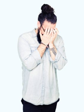 Uzun saç ve sakal yüz eller ile ağlayarak süre kapsayan üzgün ifade ile gözlüklü genç hipster adam. Depresyon kavramı.