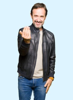 Orta yaş yakışıklı adam beckoning gel burada mutlu ve gülümseyerek el davet ile jest siyah deri ceket