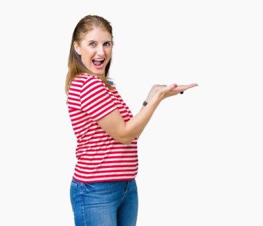 Orta yaş Olgun kadın üzerinde rahat t-shirt giyen izole arka plan el ve reklam mutlu ve kendinden emin gülümseyen sunulması avuç, yanında işaret