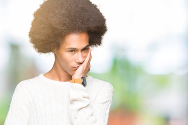 Kış kazak düşünme seyir giyen afro saçlı genç Afro-Amerikan adam yorgun ve sıkılmış çapraz silah depresyon sorunları ile.