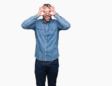 Yakışıklı delikanlı, dilini parmaklarının arasından baktığını yapışmasını dürbün gibi ok jest yapıyor izole arka plan üzerinde. Deli ifade.