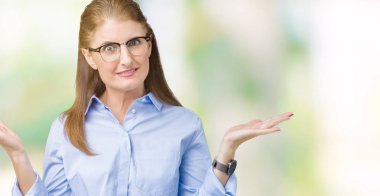 Güzel orta yaş olgun iş kadını izole arka plan clueless ve şaşkın bir ifadeyle kollar ve eller kaldırdı üzerinde gözlük takıyorum. Şüphe kavramı.