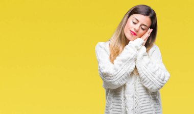 Genç güzel kadın rahat beyaz kazak uyku yorgun hayal ve ile gülümseyen gözleri kapalı iken ellerle birlikte poz izole arka plan üzerinde.