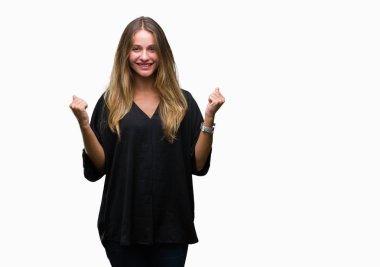 Genç güzel sarışın kadın kutluyor izole arka plan üzerinde şaşırttı ve başarı için kaldırdı kollarını açarak hayret ve gözleri açık. Kazanan kavramı.