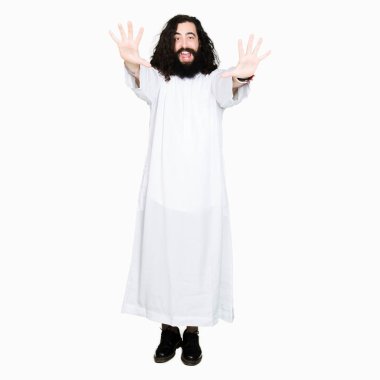 Gösterilen ve parmakları ile işaret İsa Mesih giyinen adam number ten kendinden emin ve mutlu gülümseyerek süre.