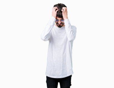 Yakışıklı delikanlı çünkü umutsuz ve stresli baş ağrısı acı izole arka plan üzerinde güneş gözlüğü takıyor ağrı ve migren. Ellerini kafasına.