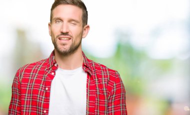 Seksi ifade, neşeli ve mutlu yüz ile kameraya bakarak rahat gömlek giyen yakışıklı adam.