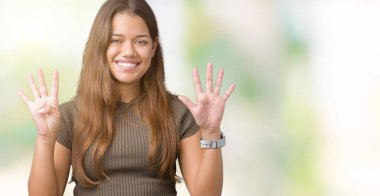 Genç güzel esmer kadın gösterilen ve parmakları ile işaret izole arka plan üzerinde numara 9 kendinden emin ve mutlu gülümseyerek süre.