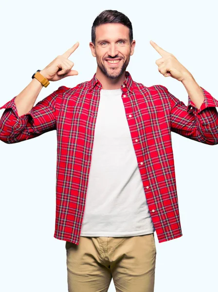 Pohledný Muž Neformální Košili Úsměv Ukazující Hlavu Oběma Rukama Skvělý — Stock fotografie