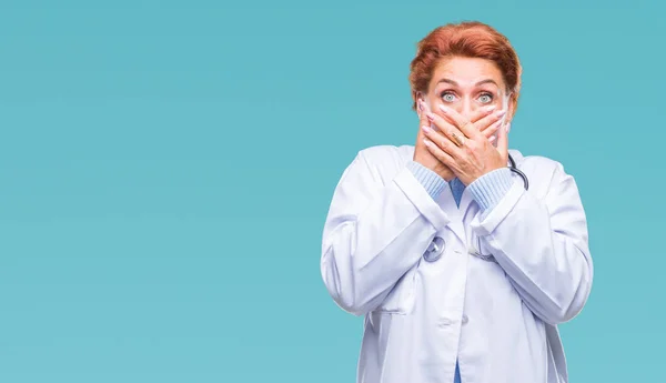 高级白种人医生妇女穿着医疗制服在孤立的背景震惊覆盖嘴与手的错误 秘密概念 — 图库照片