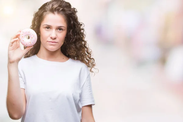 Ung Brunette Pige Spiser Donut Isoleret Baggrund Med Trygt Udtryk - Stock-foto