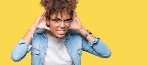 美丽的年轻非洲美国女人戴眼镜在孤立的背景试图听到双手对耳朵的手势 好奇八卦 听力问题 — 图库照片
