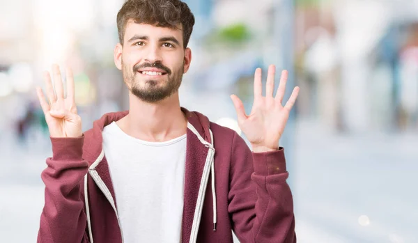 孤立した背景表示と指で上向きに若いハンサムな男ナンバー ナイン自信を持って 幸せな笑みを浮かべて — ストック写真