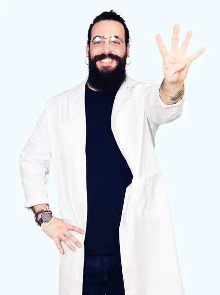 医生治疗师男子长头发和熊穿着白色外套显示和指向与手指第四 同时微笑着自信和快乐 — 图库照片