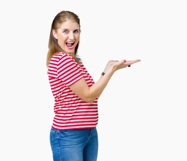 中年成熟的女人穿着休闲 T恤在孤立的背景指向一边 手和开放的手掌 呈现广告微笑快乐和自信 — 图库照片