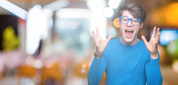 Joven Hombre Guapo Con Gafas Azules Sobre Fondo Aislado Celebrando — Foto de Stock