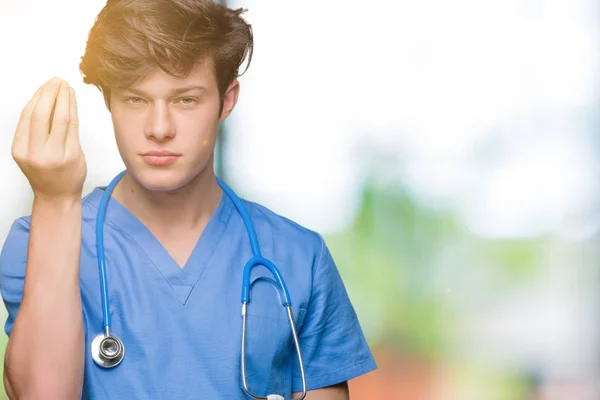 Νεαρός Γιατρός Φορώντας Ιατρική Στολή Πέρα Από Απομονωμένο Υπόβαθρο Κάνει — Φωτογραφία Αρχείου