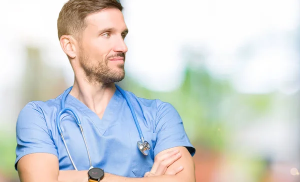 Guapo Doctor Hombre Vistiendo Uniforme Médico Sobre Fondo Aislado Sonriendo —  Fotos de Stock