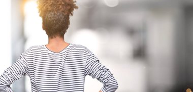 Güzel genç Afro-Amerikan kadın geriye doğru uzakta silah ile vücut üzerinde seyir ayakta izole arka plan üzerinde gözlük