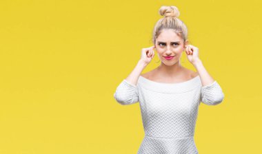 Genç güzel sarışın ve mavi gözlü kadın parmakları ile yüksek sesle müzik gürültü rahatsız ifade kulaklarıyla kapsayan izole arka plan yüzünden. Sağır kavramı.