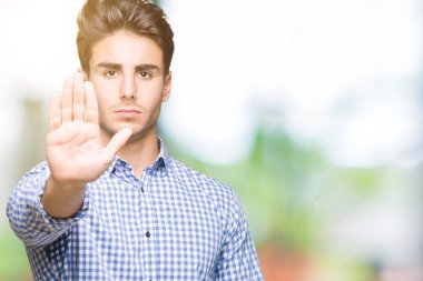 Genç yakışıklı iş adamı izole arka stop yapıyor üzerinde şarkı elin avuç ile. Negatif ve ciddi bir jest yüz ifadesiyle uyarı.