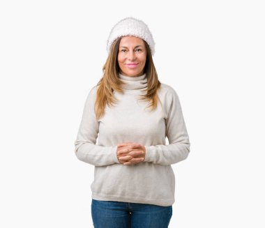 Arka plan eller üzerinde kış kazak ve şapka giyen güzel orta yaş kadın birlikte izole ve rahat ve neşeli gülümseyen parmak çarpı işareti. Başarı ve iyimser