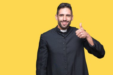 Genç Hıristiyan rahip hareketi el ile mutlu yaşasın yapıyor izole arka plan üzerinde. Başarı gösteren kameraya bakarak ifade onaylama.