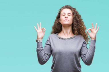 Güzel esmer kıvırcık saçlı Genç kız izole arka plan üzerinde bir kazak giyiyor rahatla ve gülümseyen gözlerle kapalı parmak jestle meditasyon yapıyor. Yoga kavramı.